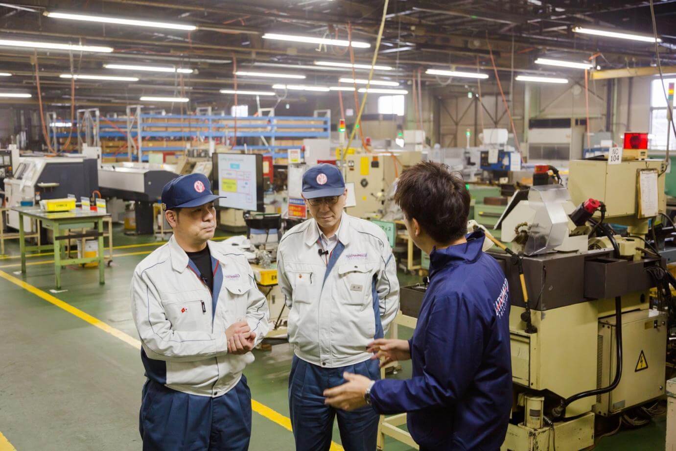 吉井憲一工場長が工場の様子を案内している風景