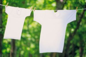 Two T-shirts hanging side by side on a washing line