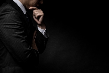 頭を抱えて悩む男性