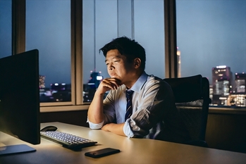 パソコンに向かう疲れた男性