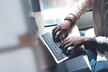 Young man working on laptop computer at home. Student men working in his room.