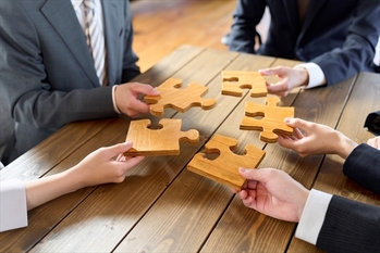 パズルのピースを持つビジネスパーソン