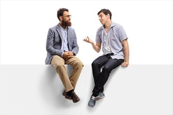 旗の上に座って話している男性たち