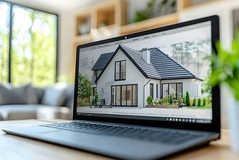 明るいリビングルームのスクリーンに、モダンな住宅建築デザインを表示するノートパソコンとオンライン住宅検索結果が表示される