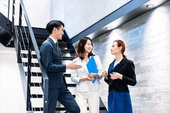 オフィスの階段で話をするビジネスパーソン