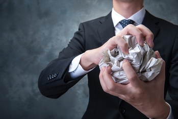 紙を丸めるビジネスマン