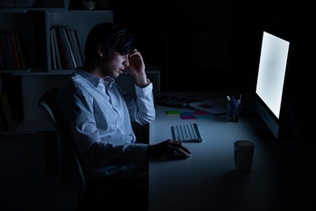 深夜の残業で疲れが溜まっているマネージャー