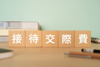 接待交際費と書かれたブロックが置かれたデスク