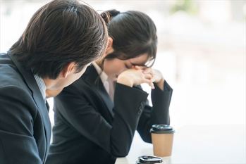 落ち込むビジネスウーマンを慰める上司の男性ビジネスマン