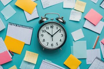 Busy office worker multitasking with a clock in the background