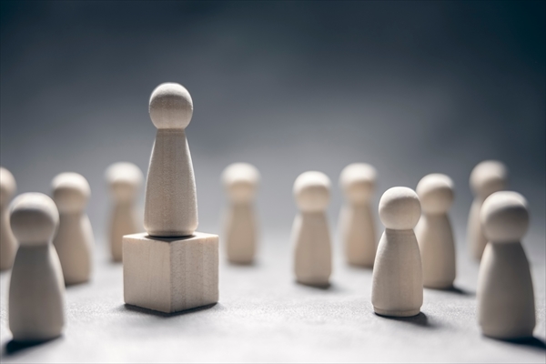 Leadership wooden business team with one person standing out from the crowd on podium