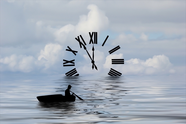 Silhouette of a boat rowing toward a clock.