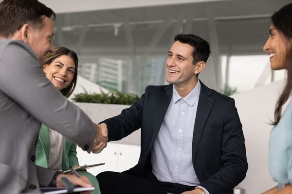 Positive confident male business partners shaking hands on brainstorming meeting
