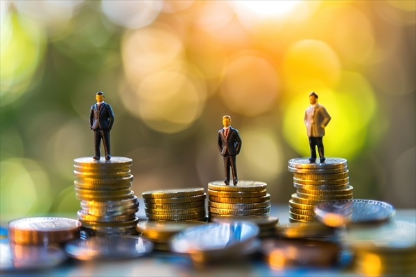 Miniature people: small figures businessmen stand on top of coins