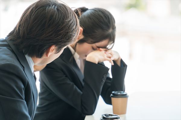 落ち込むビジネスウーマンを慰める上司の男性ビジネスマン